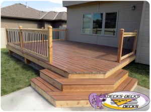 A deck with three stairs down to the lawn